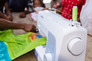 person sewing on a sewing machine