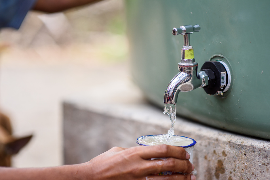 Water running out of a spout and filling up a cup