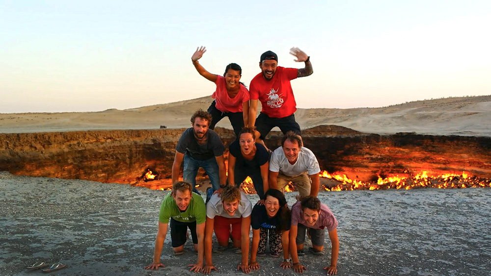 An image of a group of people crouching and balanicng on top of each other to recreate a human pyramid