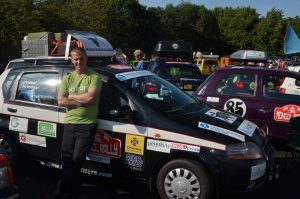 Person leans against a car at an Adventurist rally