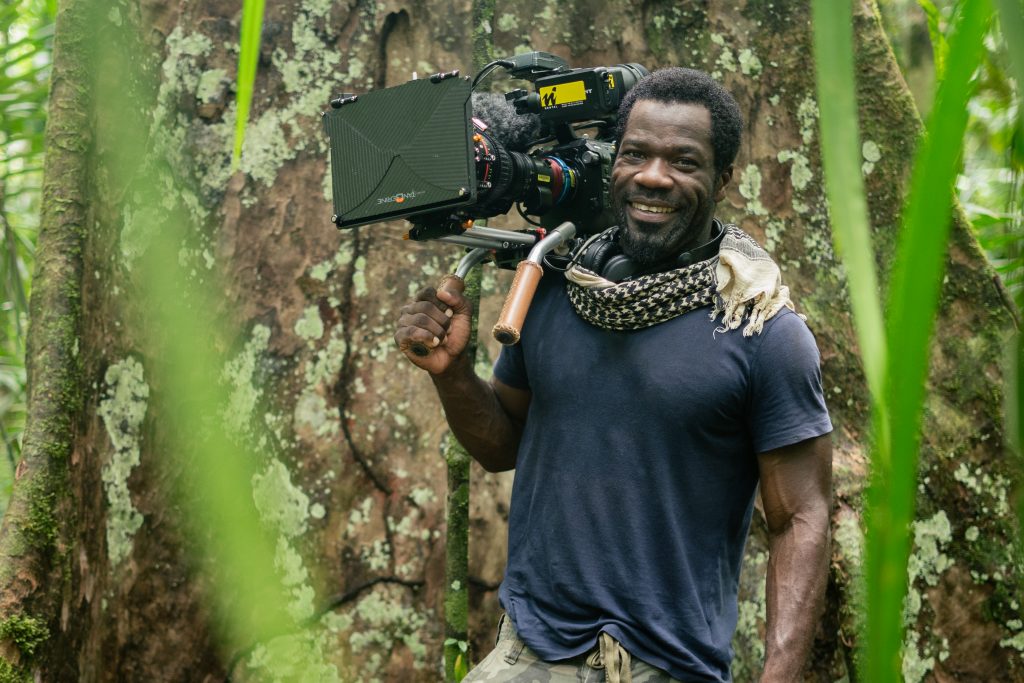 Portrait of Vianet in front of rainforest buttress roots.