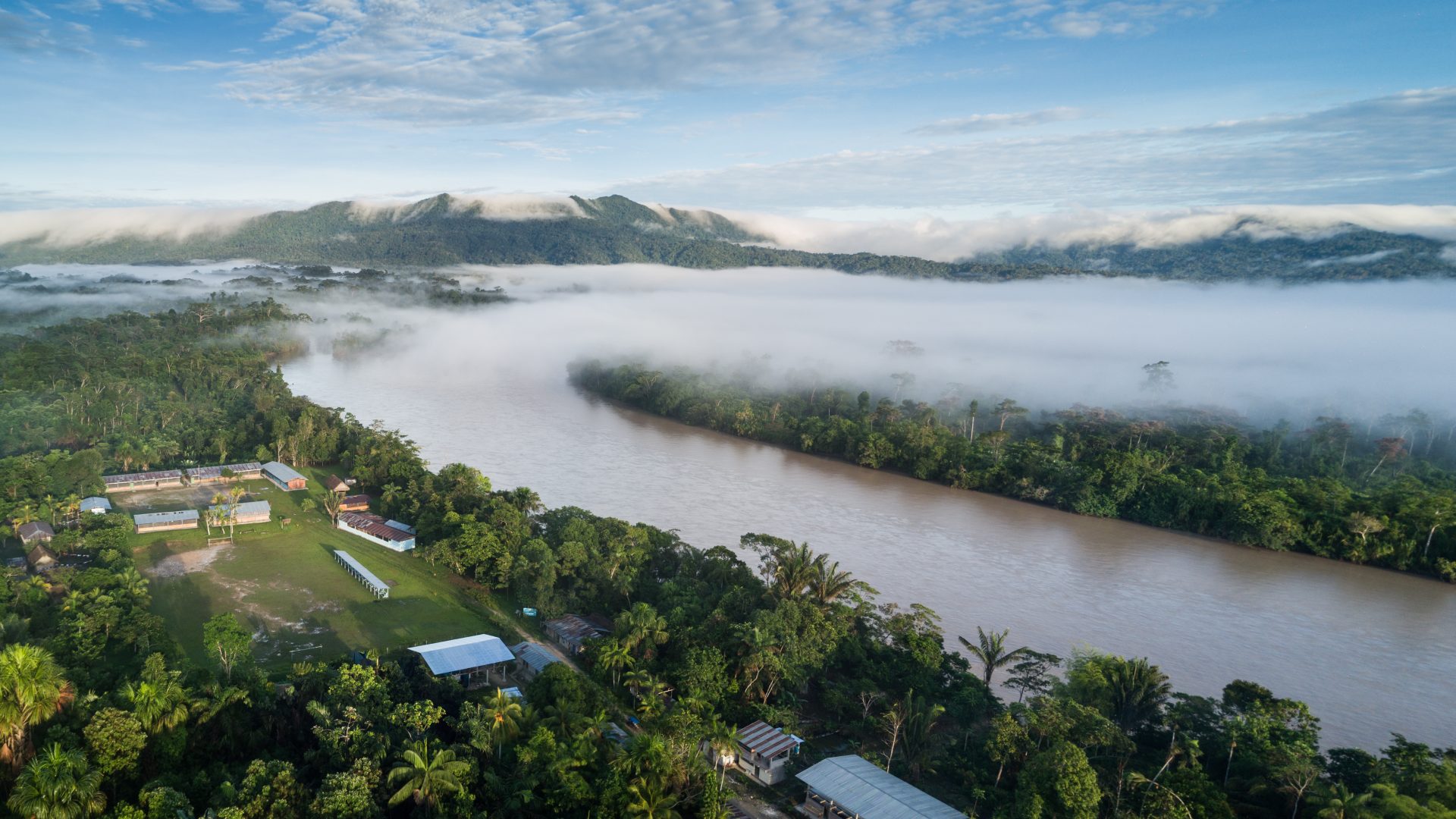 The Rio Maranon curves past the village of Urakuza toward distant, forest covered mountains.