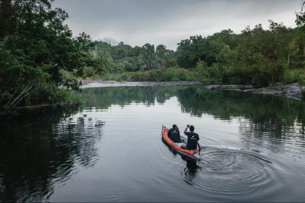 Two men kayaking down a river in the Cambodia Croc Site