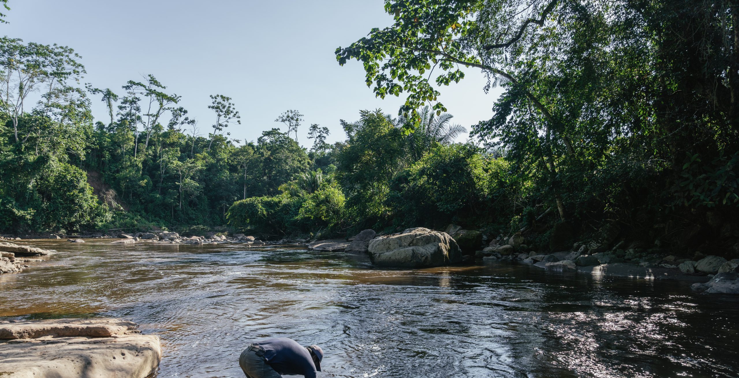 Jaime rinses his hands in the cool waters of the river near Tinkareni, Peru.