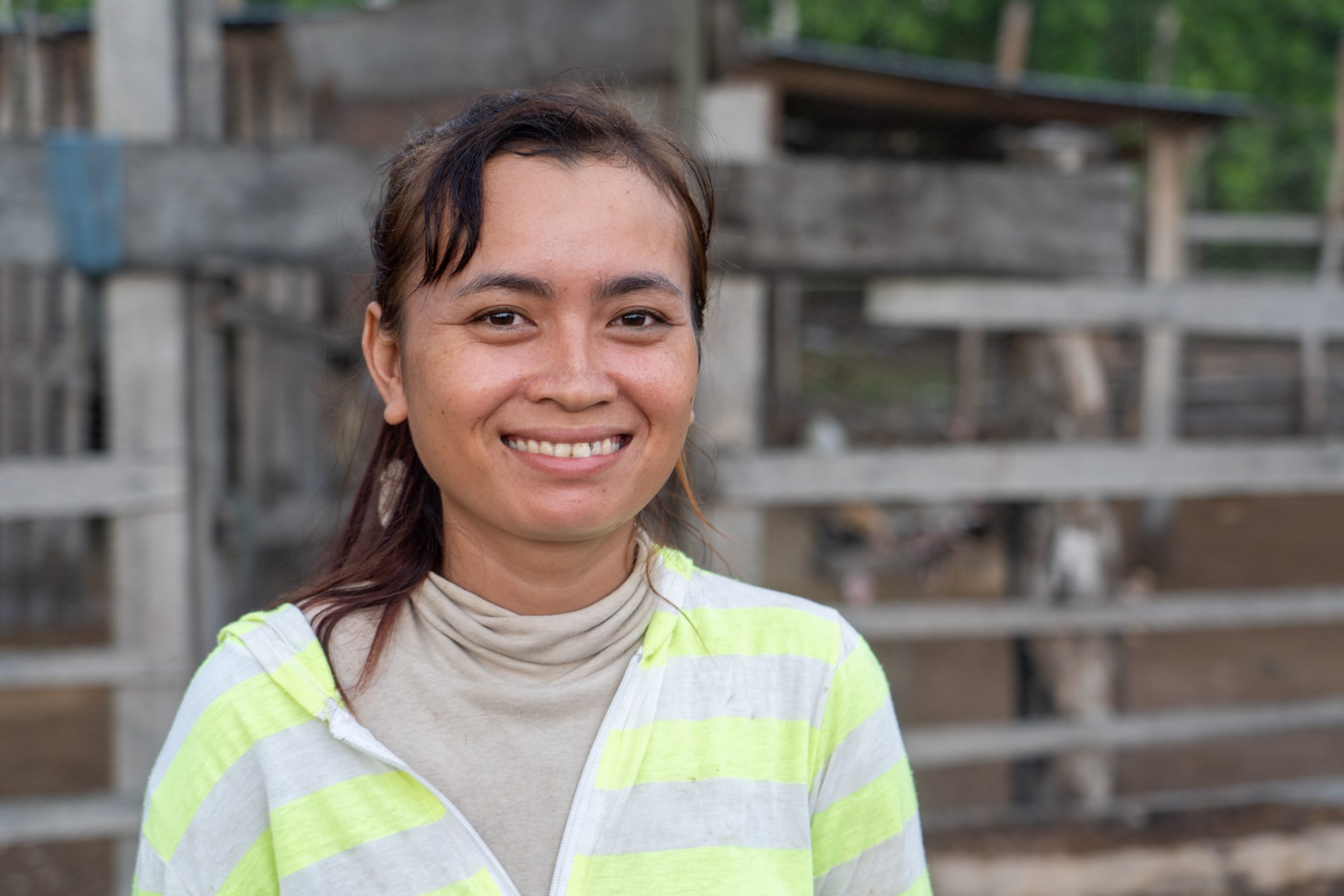 close up of a woman slightly smiling, wearing a bright-striped top