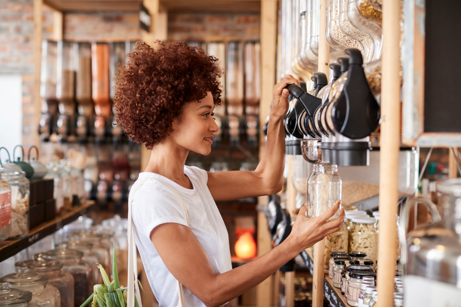 A woman refills her glass jar with oats, from a plastic free store.