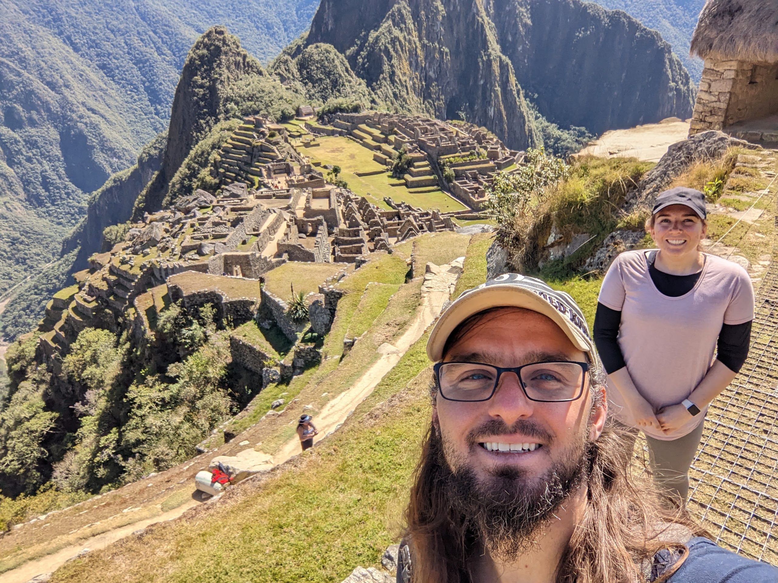 Luke and his wife, Laine, take a selfie in front of Machu Picchu, both have big smiles on their face.