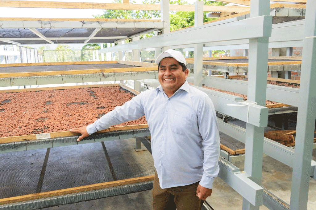 Wilson Barturen, of Cool Earth, stands in front of cacao seeds that are ready for roasting.