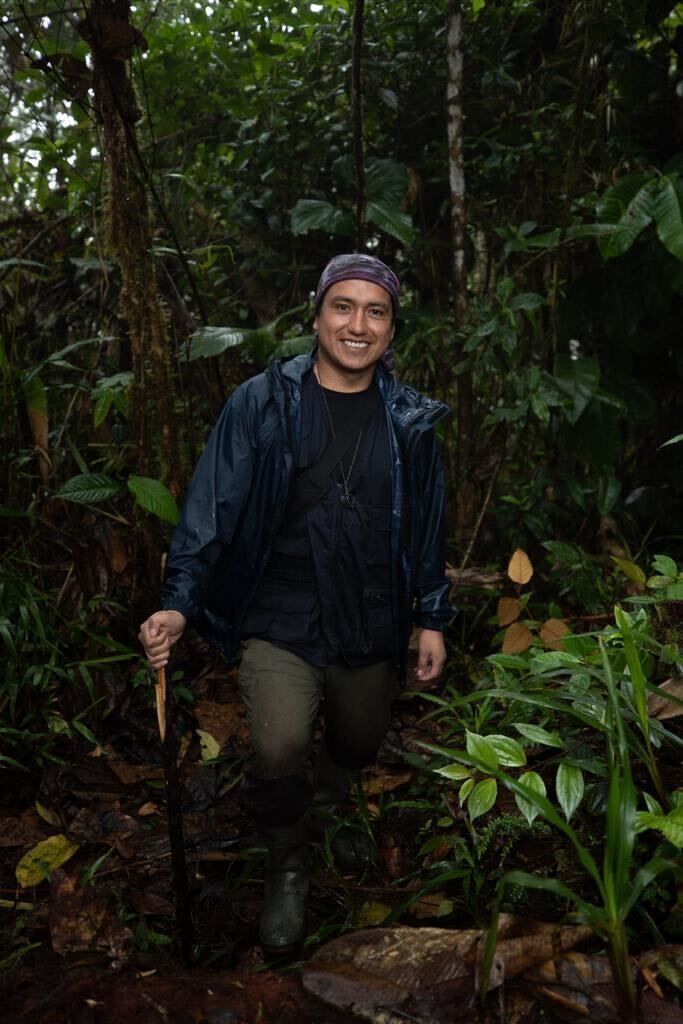 Marco Monteros standing in rainforest leaning on a stick.