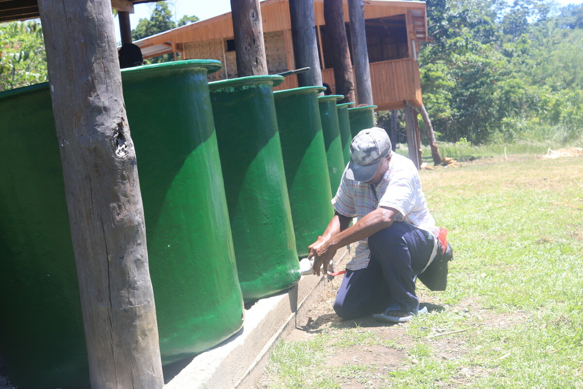 Edward Isaac, working for RWSSP in our collaborative clean water project, fits taps to rainwater tanks to be installed for each household in Sololo